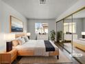 A staged bedroom with a large mirror closet, a queen bed, and bright window at 913 Boulder Springs Dr # 202, Las Vegas, NV 89128