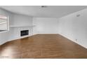 Empty living room features hard flooring, a fireplace and mantle, and natural light at 913 Boulder Springs Dr # 202, Las Vegas, NV 89128