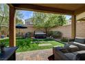 Covered patio with outdoor seating overlooking a lawn and hot tub at 9921 Rams Leap Ave, Las Vegas, NV 89166