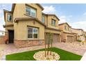 Charming two-story home featuring stone accents, a brick driveway, and a manicured lawn under a clear blue sky at 10372 Thurso Ave, Las Vegas, NV 89166