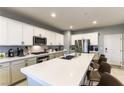 Modern kitchen features stainless steel appliances, white cabinets, and a large island with seating for four at 10372 Thurso Ave, Las Vegas, NV 89166