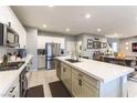 Bright and airy kitchen boasts stainless steel appliances and a large island that opens to the dining area at 10372 Thurso Ave, Las Vegas, NV 89166