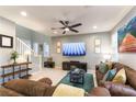 Inviting living room with neutral colors, tile floors, ceiling fan and comfortable seating at 10372 Thurso Ave, Las Vegas, NV 89166