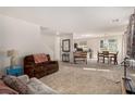 Open-concept living area with carpet, dining space, and lots of natural light at 105 Pollentia Ave, North Las Vegas, NV 89084