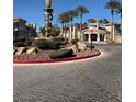 Community clubhouse with palm trees, desert landscaping, sculpture, and brick-paved roads at 10550 W Alexander Rd # 2183, Las Vegas, NV 89129