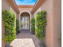 Charming front entrance featuring a pathway lined with symmetrical greenery and double doors at 10581 Santo Marco Ct, Las Vegas, NV 89135