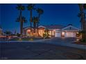 Charming single-story home with beautiful desert landscaping and a three-car garage at twilight at 11037 Clarion Ln, Las Vegas, NV 89134