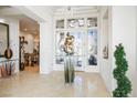 Elegant foyer with neutral tile flooring, statement glass door, and stylish decor creating a luxurious entrance at 11037 Clarion Ln, Las Vegas, NV 89134