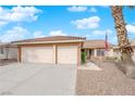 Charming single-story home featuring a three-car garage, desert landscaping, and American flag at 206 Red Cloud Ter, Henderson, NV 89015