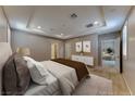 Cozy main bedroom with neutral tones, recessed lighting, a tray ceiling and an ensuite bathroom at 2767 Flowing Breeze St, Henderson, NV 89044