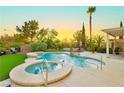 Sparkling swimming pool and spa surrounded by lush landscaping and mature trees at 2859 Hayden Creek Ter, Henderson, NV 89052