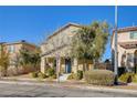 Charming two-story home with a well-manicured front yard and a welcoming blue front door adorned with a festive wreath at 3232 Romanesque Art Ave, Henderson, NV 89044