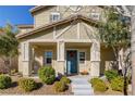 Inviting front porch with a blue door, complemented by neat landscaping and a cozy entrance for a warm welcome at 3232 Romanesque Art Ave, Henderson, NV 89044