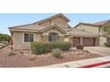Inviting single-story home with three car garage, stone accents, desert landscaping, and a paver driveway at 3728 Granada Gorge Ln, North Las Vegas, NV 89084