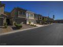 Exterior view of contemporary townhomes with individual garages and community landscaping at 3783 Canis Minor Ln # 6104, Henderson, NV 89052