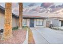 Charming entryway with decorative landscaping, an iron gate, and a concrete path at 4145 Plumtree St, Las Vegas, NV 89115