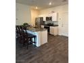 Modern kitchen features stainless steel appliances, granite countertops, and dark wood flooring at 532 Clearsable Ave, Henderson, NV 89044