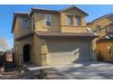 Two-story home featuring a large two car garage, stucco siding, and a tile roof at 6182 Blue Rapids Ct, Las Vegas, NV 89139