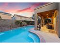 Inviting pool with a tanning ledge, water feature, and landscaped patio under a covered area, perfect for outdoor relaxation at 648 Sunrise Lake Pl, Henderson, NV 89002