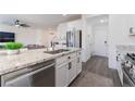 Modern kitchen island features granite countertops, stainless steel appliances, and sleek white cabinetry at 7132 Sayonara Vista St, North Las Vegas, NV 89084