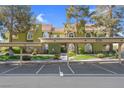 Exterior view of a condo with covered parking, set against a backdrop of mature trees and manicured lawns at 7950 W Flamingo Rd # 1003, Las Vegas, NV 89147