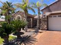 Charming single-story home with a stone facade, mature palm trees, and a well-manicured landscape at 8209 Chapelle Ct, Las Vegas, NV 89131
