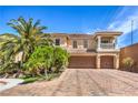 Beautiful two-story home with a dual garage, balcony, and mature landscaping at 8454 Mondavi Hill Ct, Las Vegas, NV 89139