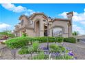 Lovely beige two-story home with manicured bushes and mature landscaping in a desert setting at 8824 Prague Ct, Las Vegas, NV 89147