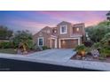A beautiful two-story home with a three-car garage, landscaped front yard, and warm exterior lighting at 9 Contra Costa Pl, Henderson, NV 89052