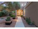 Inviting front entrance with stone walkway, manicured landscaping, and warm exterior lighting at 9 Contra Costa Pl, Henderson, NV 89052