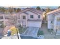 A quaint two-story home, showcasing a tidy yard and a convenient two-car garage, captured from an aerial perspective at 9879 Jazzy June St, Las Vegas, NV 89183
