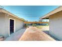 Spacious backyard featuring a brick-paved patio, desert landscaping, and an open garage at 1801 Griffith Ave, Las Vegas, NV 89104