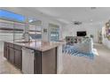 Bright, open-concept kitchen featuring a granite island, stainless steel appliances, and seamless flow to the living area at 2494 Veronella St, Henderson, NV 89044