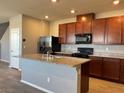 Spacious kitchen featuring dark cabinets, a large island, granite countertops, and modern stainless-steel appliances at 2664 Frabiele St, Henderson, NV 89044