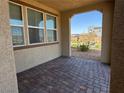 Covered patio with brick pavers, offering a cozy outdoor space with view of the landscaped neighborhood at 2664 Frabiele St, Henderson, NV 89044