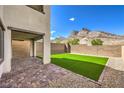 Spacious backyard with artificial grass, stone pavers, gravel, and a block wall with mountain views at 11640 Desert Hollow Ave, Las Vegas, NV 89138