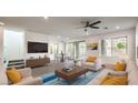 Bright living room with modern furnishings, sleek ceiling fan, and sliding glass doors leading to the backyard at 11640 Desert Hollow Ave, Las Vegas, NV 89138