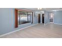 A spacious living room with large windows, new light-colored wood floors, and neutral-toned walls at 1643 E St, Las Vegas, NV 89106
