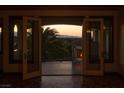 Serene balcony featuring an outdoor fireplace, views, and an open doorway into a luxury home at 1800 Melfi Ct, Henderson, NV 89012