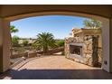 Outdoor balcony with a stone fireplace, iron railing, and a view of the community at 1800 Melfi Ct, Henderson, NV 89012