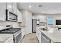 Modern kitchen with stainless steel appliances, white cabinets, and granite countertops at 4333 Glossier Ave, North Las Vegas, NV 89084
