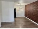 Inviting living room with wood-look floors and a brick accent wall at 5157 New Bedford Dr, Las Vegas, NV 89122