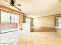 Open living room area with ceiling fan, sliding glass doors to a balcony, and tile and wood flooring at 8101 W Flamingo Rd # 1044, Las Vegas, NV 89147
