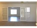 Bright living room with carpet and french doors leading to another living space with wood floors at 9904 Arbuckle Dr, Las Vegas, NV 89134