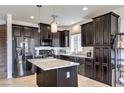 The kitchen features dark cabinetry, a center island with light countertops and stainless steel appliances at 10509 Hartford Hills Ave, Las Vegas, NV 89166