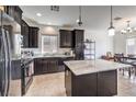 The kitchen features dark cabinetry, a center island with light countertops and stainless steel appliances at 10509 Hartford Hills Ave, Las Vegas, NV 89166