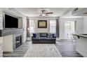 Bright living room with a decorative fireplace, ceiling fan, and wood-look flooring at 1713 Queen Victoria St # 104, Las Vegas, NV 89144
