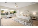 Serene bedroom with neutral tones, large windows, ceiling fan, and a plush bed on a patterned rug at 2264 Savannah River St, Henderson, NV 89044