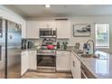 Modern kitchen featuring stainless steel appliances, granite countertops, and white cabinetry at 2657 Fawn Beige Ct, North Las Vegas, NV 89086