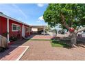 Backyard of a single-story home featuring a covered patio, gravel yard, and mature tree with hanging chair at 2809 Webster St, North Las Vegas, NV 89030